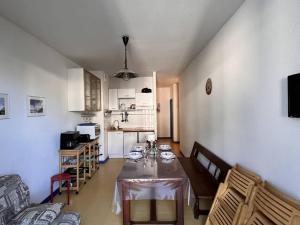 コトレにあるAppartement à Cauterets - 5/6 pers., Terrasse, 30 m², Parking Proche - FR-1-234-158のテーブルとキッチンのあるリビングルーム