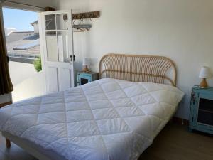 a bedroom with a white bed and a window at Villa bohème chic à Sauzon avec vue mer et wifi - FR-1-418-174 in Sauzon