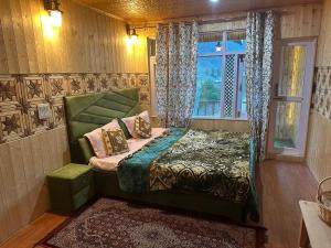 a bedroom with a bed in a room with a window at D’SHIEKHS RESORT GUREZ in Kanzalwan