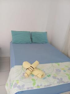 a blue bed with two towels and two pillows on it at Recanto do Angelo in Salvador +16 photos