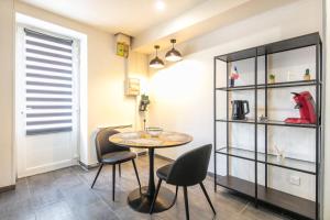a dining room with a table and chairs and a shelf at Le Refuge du Val - Appartement vue montagne in Merlas