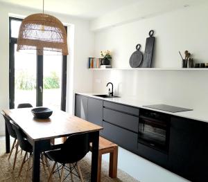kuchnia ze stołem, zlewem i kuchenką w obiekcie PENINSULAR HOUSE w mieście Camaret-sur-Mer