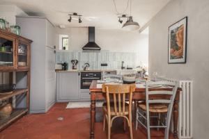 a kitchen with a table and chairs in a room at Les Gîtes de l'Atelier - Gîtes de charme en Forêt de Fontainebleau in Saint-Martin-en-Bière