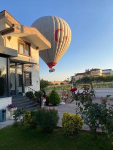 a hot air balloon flying over a house at Cappadocia Villa Comfort in Nevşehir