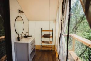 a bathroom with a sink and a mirror and a window at The Richbourg, Lux Safari Tent in Cadiz
