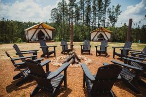 a group of chairs sitting around a fire with tents at The Richbourg, Lux Safari Tent in Cadiz
