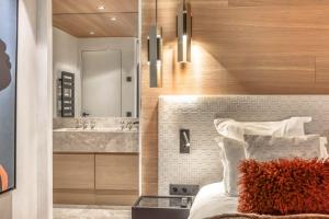 a bedroom with a bed and a bathroom with a sink at Appartement Oberland in Megève +19 photos