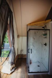 un bagno con doccia in vetro in una stanza di The Underwood, Lux Safari Tent a Cadiz