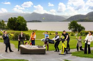 a group of people standing around a man laying on a couch at The Europe Hotel & Resort in Killarney