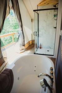 e bagno con finestra e vasca. di The Underwood, Lux Safari Tent a Cadiz Altre 34 foto