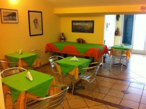 una sala da pranzo con tavoli e sedie verdi di B&B Miramare a Giardini Naxos