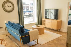 a living room with a blue couch and a tv at Charles Hope Salisbury Centre in Salisbury