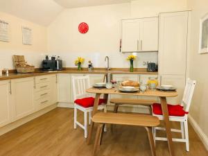 a kitchen with a table and chairs and a kitchen with white cabinets at Cottage in North Somerset in Clevedon +22 photos