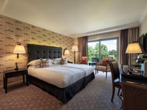 a hotel room with a large bed and a balcony at The Europe Hotel & Resort in Killarney
