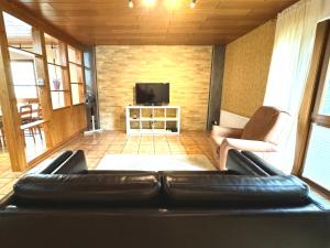 a living room with a leather couch and a television at H&H Home - Full equipped Apartment near Mercedes in Sindelfingen in Sindelfingen