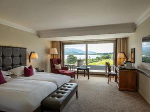 a hotel room with a bed and a large window at The Europe Hotel & Resort in Killarney