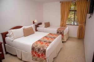 a hotel room with two beds and a window at Hotel y Cabañas - Centro Vacacional Comfandi Lago Calima in Calima +91 photos