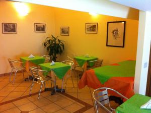 a restaurant with green tables and chairs in a room at B&B Miramare in Giardini Naxos