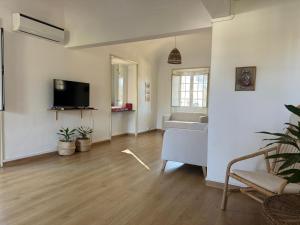 Una sala de estar con un sofá y un televisor. en T'Inácia Guest House, en Évora