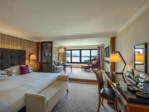 a hotel room with a large bed and a living room at The Europe Hotel & Resort in Killarney