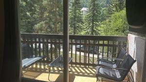 a balcony with two chairs and a bench on a porch at Nid douillet La Salle les Alpes, Serre Chevalier in La Salle Les Alpes
