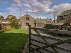 a wooden fence in front of a stone house at Low Fold Cottage in Penrith