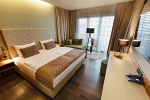 塔亚河畔拉镇Therme Laa Hotel Silent Spa Villas的一间带大床的卧室和一间客厅
