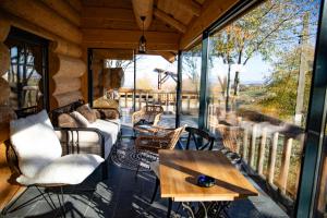 a screened in porch with a table and chairs at Casa de pe deal Sinteu in Şinteu