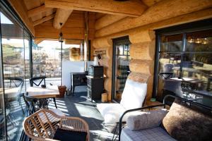 a porch with a couch and chairs on a patio at Casa de pe deal Sinteu in Şinteu +7 photos
