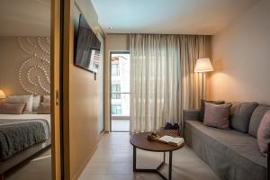 a hotel room with a couch and a table at Eden Roc Resort - All Inclusive in Kallithea Rhodes +85 photos