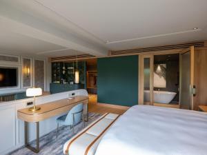 a bedroom with a bed and a desk and a tub at The Europe Hotel & Resort in Killarney