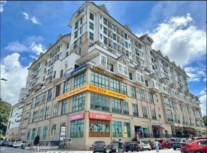 un grande edificio con auto parcheggiate di fronte di Hello Kitty HomeStay - Cameron Highlands - Spacious Studio - Perfect for Families - Sleeps 4 and Baby a Tanah Rata
