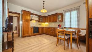 una cucina con un tavolo di legno e una sala da pranzo di Casa Veronika ad Arcade Altre 20 foto