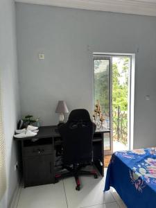 a desk with a chair in a room with a bed at YNW Terminal Loft in Méfou