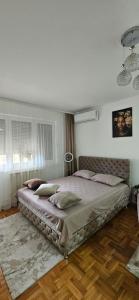 SremčicaにあるApartman Tajnaの大きなベッドと枕のある寝室 +13枚の写真