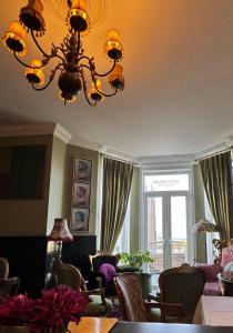 a living room with a chandelier and a table and chairs at The White House Hotel in Newquay +37 photos