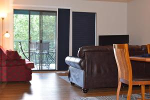 a living room with a leather couch and a table at Grant's Condo in The Greens in Branson +15 photos