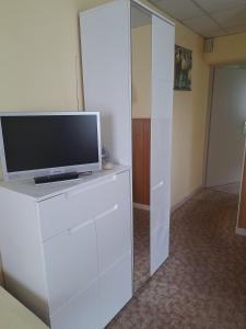 a television on a white dresser in a room at Ferienwohnung-Nr-2-Quitte in Radebeul