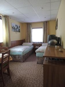 a hotel room with two beds and a desk at Ferienwohnung-Nr-2-Quitte in Radebeul