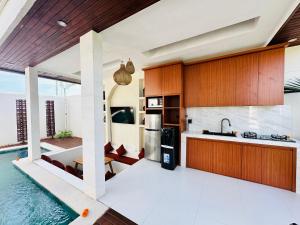 Una cocina abierta con piscina y una casa. en Kelapa Villa Mambal, en Mambat