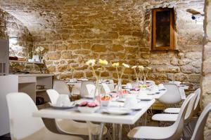 a dining room with white tables and white chairs at Hôtel Marais de Launay in Paris