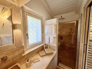 Un baño con ducha, lavabo y espejo. en Petra d'arana, en Palau
