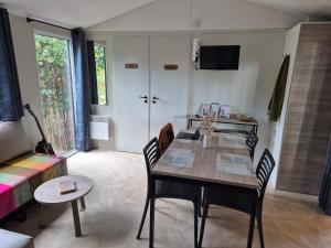 ein Wohnzimmer mit einem Tisch und Stühlen in einem Zimmer in der Unterkunft Cottage Les 2 Chardon in La Teste-de-Buch