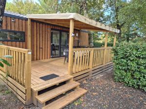 eine Holzterrasse mit einem Pavillon in der Unterkunft Cottage Les 2 Chardon in La Teste-de-Buch