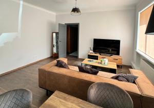 a living room with a couch and a flat screen tv at EVIS LTD apartments 3 in Rēzekne
