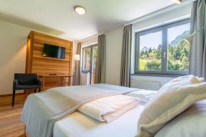 a hotel room with a bed and a window at Heimat Natur Resort in Prägraten