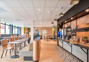 モンルージュにあるB&B HOTEL Paris Porte d'Orléansの食堂のテーブルと椅子付きレストラン