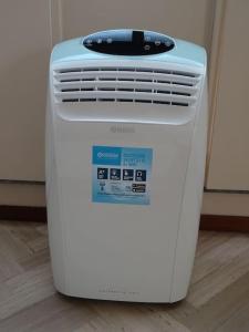 a white air conditioner sitting on a floor at Ampio monolocale vicino al lungolago di Lecco in Lecco