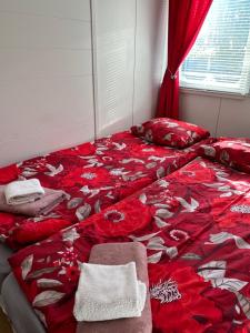 a bedroom with a bed with red flowers on it at Aurora Center 3 in Rovaniemi