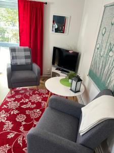a living room with two chairs and a tv at Aurora Center 3 in Rovaniemi